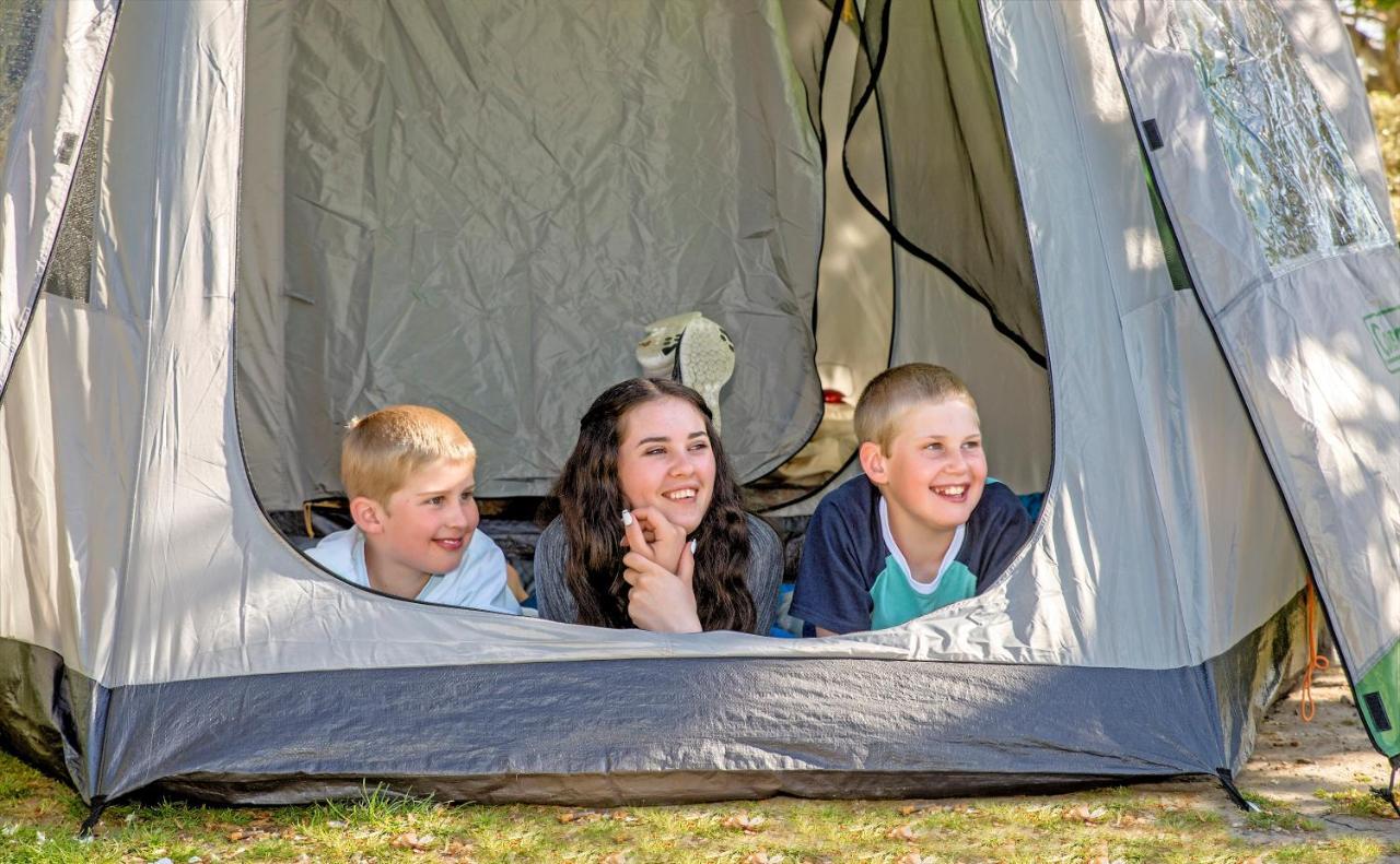 Taupo Debretts Spa Resort Экстерьер фото The photo shows three children inside a tent, looking out from an opening. Two boys are on the left, one with short blonde hair and the other with light brown hair, while the girl in the middle has long dark hair. They all appear to be happy and enga